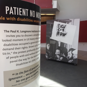 Two posters, on the left is a poster that says, "Patient No More" and then smaller text describing the exhibit. On the right is a black and white photo of people crowded in front of a building with one sign that says: "Sign 504 now"